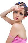 Beautiful model with hair curlers poing on white background