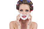 Model touching her face with shaving foam on white background