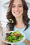 Brunette having salad in her kitchen