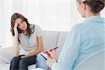 Worried woman sitting with therapist looking at her and advising her