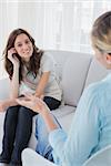 Happy woman sitting with her therapist talking to her at a private session