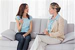 Woman talking to her psychologist  and sitting on the couch