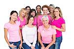 Voluntary cheerful women posing and wearing pink for breast cancer on white background