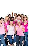 Voluntary cheerful women wearing pink for breast cancer on white background