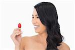 Happy natural brown haired model with strawberry on white background