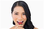 Attractive brown haired model eating strawberry on white background