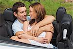 Couple in love cuddling in the backseat of convertible