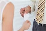 Businessman passing his business card in bright office