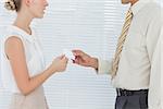 Business people exchanging business card in bright office