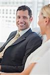 Cheerful businessman looking at his attractive blond colleague in bright office