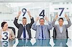 Cheerful interview panel holding signs giving marks in bright office