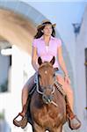 Young attractive woman riding a horse at a castle forecourt, Germany