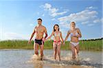 Happy Family Running in Shallow Water of Lake in Summer, Bavaria, Germany