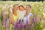 Close-up of a woman with her daughter and her mother in a flower meadow in summer, Bavaria, Germany.