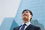 Portrait of young smiling businessman outside glass building