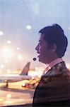 Double exposure of businessman with headset and airport