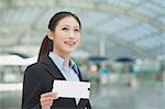 Businesswoman at the airport with airplane ticket