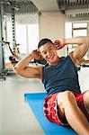 Young man doing sit-ups in the gym