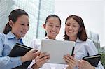 Three young businesswomen discussing outdoors