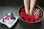 Woman's Feet Soaking in Water with Rose Petals
