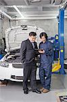 Businessman with Mechanic in Auto Repair Shop