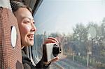 Young Woman Taking Photographs Outside Train Window