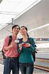 Young Couple Checking The Train Schedule