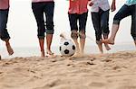 Young Friends Playing Soccer on the Beach