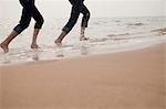 Young Couple Running in the Waves