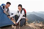 Young couple setting up the tent