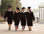 Young Graduates Walking Across Campus