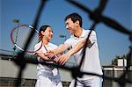 Young girl playing tennis with her coach