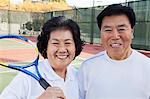 Mature couple playing tennis, portrait