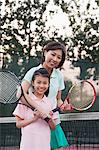 Mother and daughter playing tennis, portrait