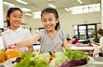 Students reaching for healthy food in school cafeteria