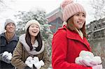 Three friends Holding snow balls in snow in park