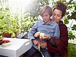 Mother peeling apple for son outdoors