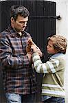 Father and son examining chicken