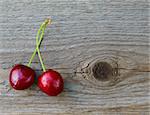 Two Fresh Ripe Red Sweet Cherries on Wooden Background. Closeup. Space for Text