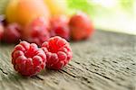 Ripe Sweet Raspberries on the Wooden Table Against the Heap of Summer Fruits and Berries