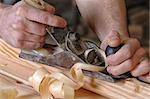 Man hands with carpenters plane on wooden background