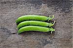 fresh pea pods in a row, on wood table