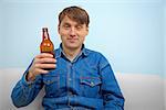 Man relaxing with a bottle of beer at home