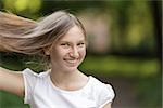 young girl holding hair and smiling, horizontal