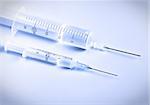 two syringes with remedy on blue background