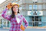Portrait of Young Attractive Female Construction Worker Wearing Gloves, Hard Hat and Protective Goggles at Construction Site.