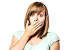 Shocked young girl who is afraid and keeps up with eyes wide open hand over her mouth, isolated on white background