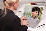 Over Shoulder of Woman In Kitchen Using Laptop - Online Chat with Nurse or Doctor on Screen.