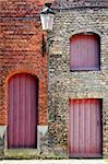 Detail of old vintage brick wall with red wooden doors and windows