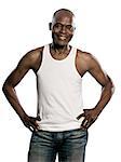 Portrait of a happy african afro American man with hands on hips jeans and sleeveless t-shirt standing in studio on white isolated background